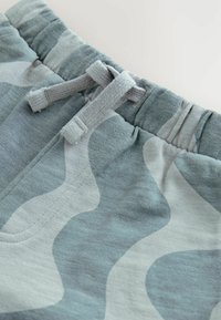 Hellblauer und grauer Camouflage-Stoff mit weicher Textur, elastischem Bund und einem verstellbaren Kordelzug.