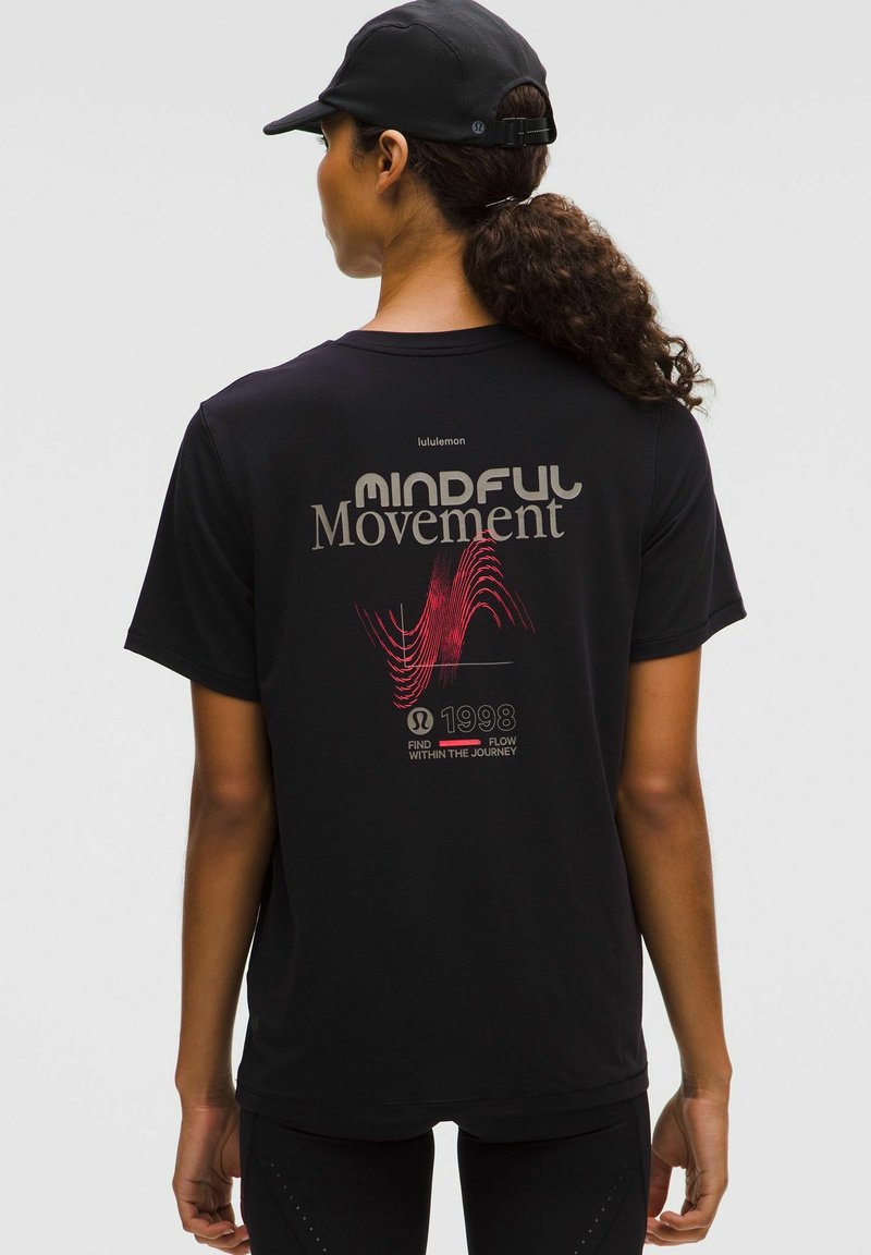 Czarna koszulka z grafiką "MINDFUL Movement" w odcieniach szarości i czerwieni, z dodatkowym tekstem oraz abstrakcyjnym wzorem fal. Krótkie rękawy, luźny krój.