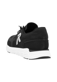 Svart idrottssko med övre del av mesh, strukturerad yta och vit gummisula. Logotypdetalj på sidan med design av rundad häl.