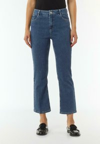 Blauwe spijkerbroek met een rechte pijp, die een hoge taille benadrukt, voorzakken heeft en zichtbare stiksels langs de naden.