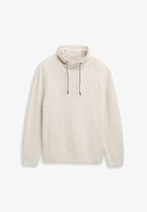 Jasno beżowy sweter z wysokim kołnierzem, prążkowaną teksturą, wzorem w drobne plamki i szarymi sznurkami. Długie rękawy i luźny krój.