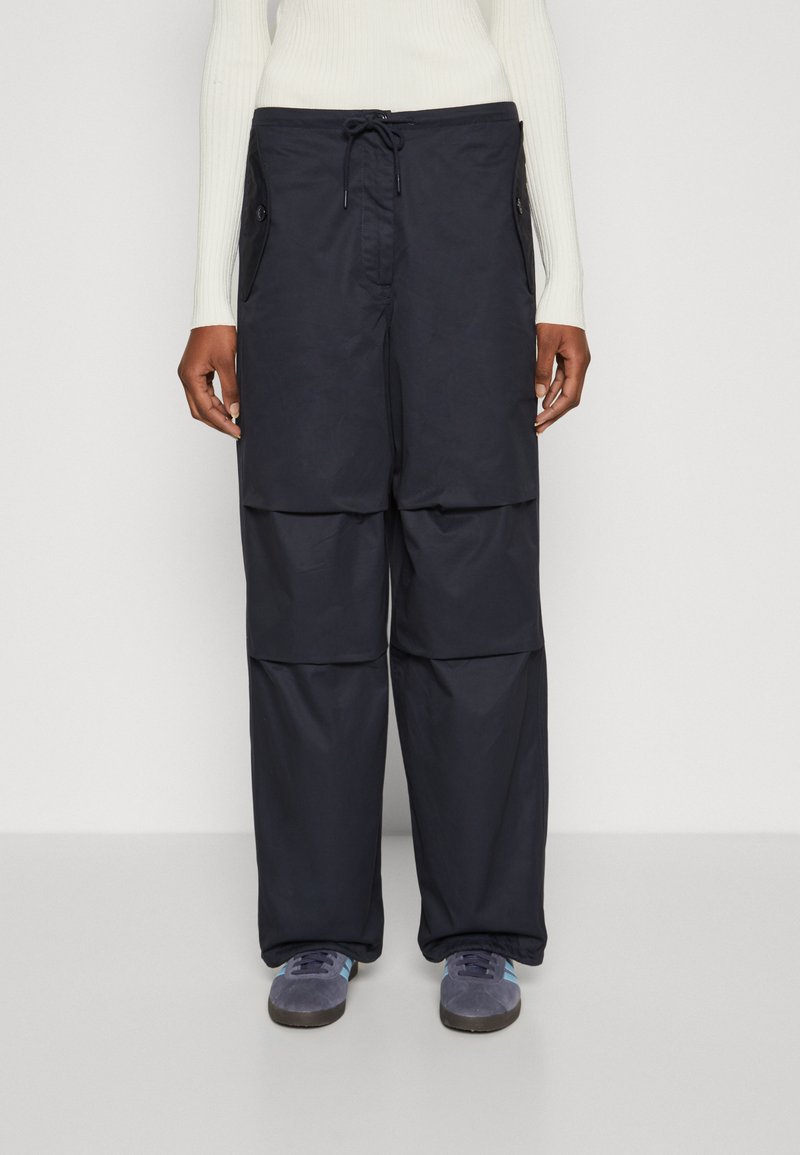 Pantalons cargo amples de couleur marine, dotés de deux poches latérales, d'une taille ajustable avec cordon de serrage et d'un tissu texturé.