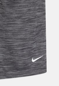 Graue Sportshorts mit einem strukturierten, melierten Muster. Mit einem weißen Nike-Logo unten rechts. Leichter Stoff, gerade geschnitten.