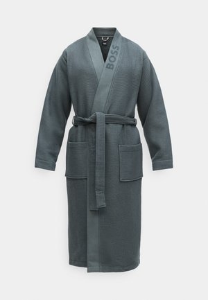 Accappatoio in tessuto a nido d'ape, di un blu scuro, con maniche lunghe, una cintura e due tasche frontali. Presenta il nome del marchio "BOSS" sul colletto.