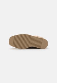 Suela de zapato en color marrón claro con textura estriada y forma redondeada. Acabado suave con un mínimo de detalles. Diseñada para ofrecer tracción y comodidad.