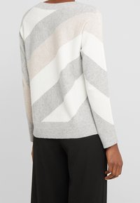 Maglione grigio, avorio e rosa pallido a righe diagonali con orlo e polsini a costine, caratterizzato da un collo a giro e una morbida texture.