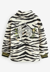 Hvid fleecejakke med sorte tigerstriber. Indeholder broderede tigre blandt grønne blade og stjerner. Sorte manchetter med gule striber.