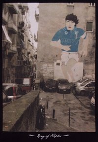 Muurschildering van een voetballer in een blauw shirt met het nummer "10" en de tekst "MARS". De achtergrond toont een smalle straat met geparkeerde auto's.