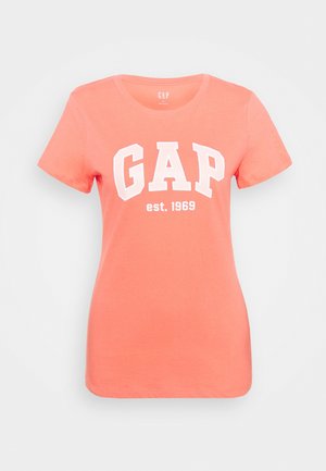 Koralfarvet T-shirt med korte ærmer lavet af bomuld, med rund halsudskæring og en hvid "GAP"-logo med "est. 1969" nedenunder. Blød tekstur.