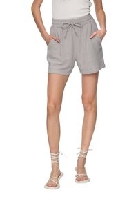 Grijze katoenen shorts met een elastische tailleband en trekkoord, met twee zijzakken. Draag met witte platte sandalen.