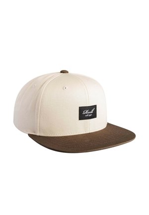 Beige baseball cap with brown flat brim and black rectangular logo patch on front reading "Reell est. 1997."