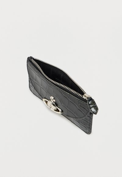 Μαύρο πορτοφόλι με ανάγλυφο μοτίβο κροκοδείλου, με ασημένιο φερμουάρ και διακοσμητικό εξάρτημα στο μπροστινό μέρος, που ξεχωρίζει για την ομαλή υφή και τον συμπαγή σχεδιασμό.