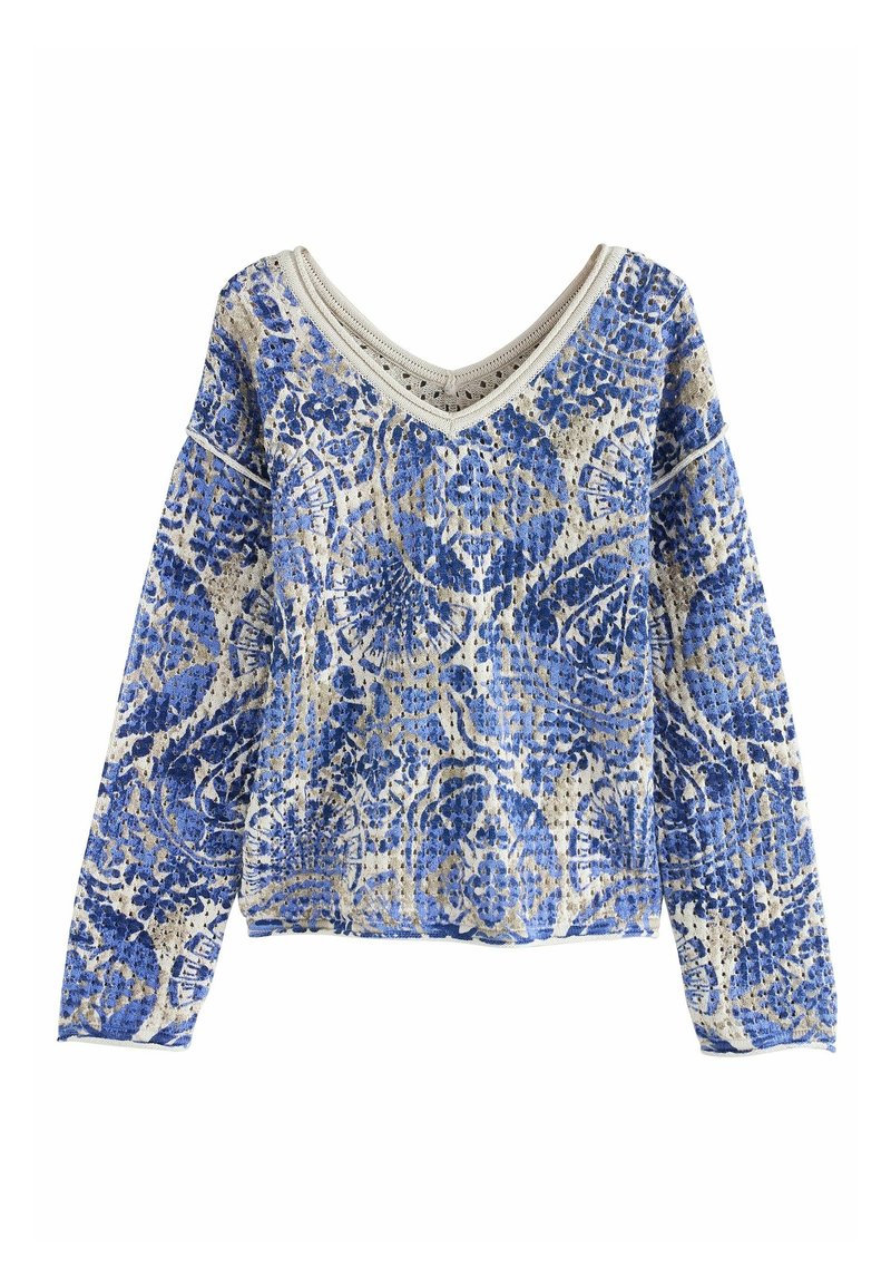 Pull à manches longues col en V avec motif floral et géométrique bleu sur tissu beige texturé.
