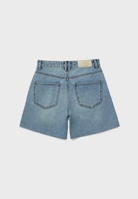 Shorts en jean bleu clair avec ourlets effilochés, deux poches arrière, passants de ceinture et une étiquette de marque blanche sur la ceinture.
