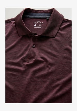 Bordó galléros póló texturált felülettel, három gombbal és gallérral. Tartalmaz egy címkét, amelyen a "NEXT ACTIVE AIM" felirat szerepel, lélegző anyagból készült.