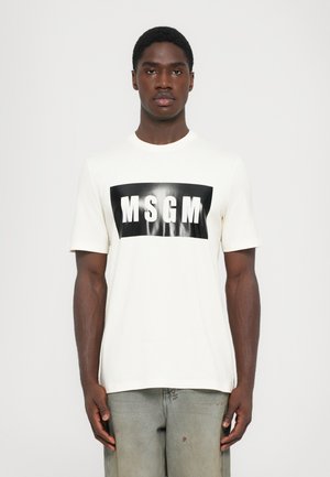 T-shirt en coton blanc avec un graphisme rectangulaire noir comportant "MSGM" en lettres blanches en gras, centré sur le devant. Manches courtes, col rond.