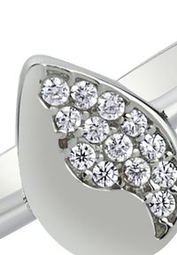 Bague en argent présentant un design incurvé avec un groupe de pierres précieuses rondes et transparentes disposées en motif décoratif d'un côté. Finition lisse.