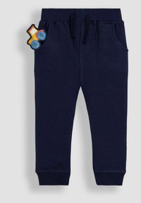 Navyblaue Sweatpants aus weichem Stoff mit elastischem Bund und Kordelzug. Mit Fronttaschen und einer Traktor-Applikation auf der Tasche.