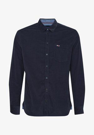 Tengerészkék, hosszú ujjú ing sima pamutból, gombos nyakkal, mellzsebbel és kontrasztos belső nyakrész részletezéssel.