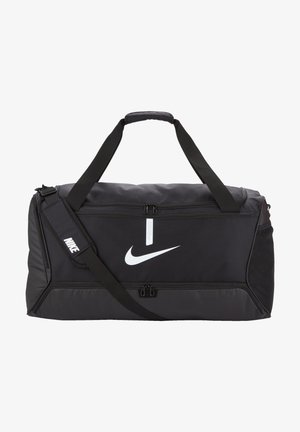 Musta Nike -duffelipussi, jossa on kaksi vetoketjullista osastoa, säädettävä hihna ja suuri valkoinen logo. Valmistettu kestävästä materiaalista.