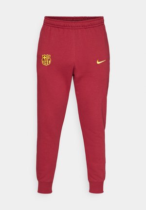 Raudoni sportiniai kelniai, pagaminti iš medvilnės mišinio, su elastingu juosmeniu, siaurėjančiomis kojomis ir geltonu Nike logotipu bei FC Barcelona herbu.