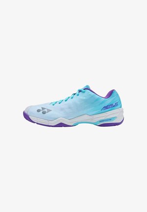 Zapatilla deportiva de corte bajo en azul claro y morado con diseño de cordones, suela blanca y marca "AERUS" en el lateral del talón.