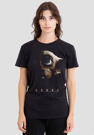 Young woman wearing black t-shirt with large close-up graphic of Dobby the elf's face and the text "DOBBY" below.