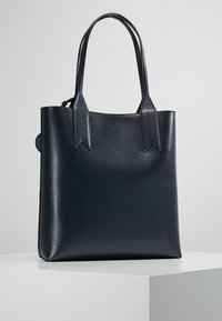 Marineblaue Leder-Umhängetasche mit glatter Textur, rechteckiger Form und flachen Griffen. Auffällige, auf den Griffen aufgenähte Akzente.