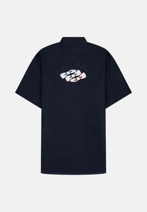 Chemise noire à manches courtes avec col, présentant un logo ovale en relief au dos avec des formes blanches et roses entrelacées et le texte "Eden Park".