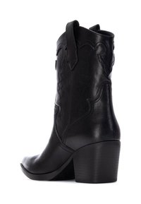 Stivale da cowboy in pelle nera con punta affusolata, design cucito in modo intricato, manico per la presa e tacco impilato. Texture liscia.