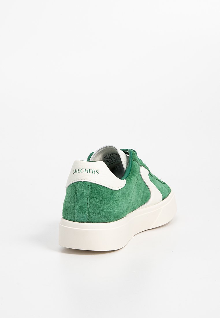 Groene suède sneakers met een witte accent, ronde vorm en een gestructureerd oppervlak. Met de merknaam "SKECHERS" op de hiel.