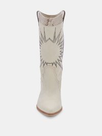 Bota vaquera de cuero blanco con puntera afilada, diseño de estrella embosada y acentos similares a piel de serpiente en la parte superior; una textura limpia y suave.