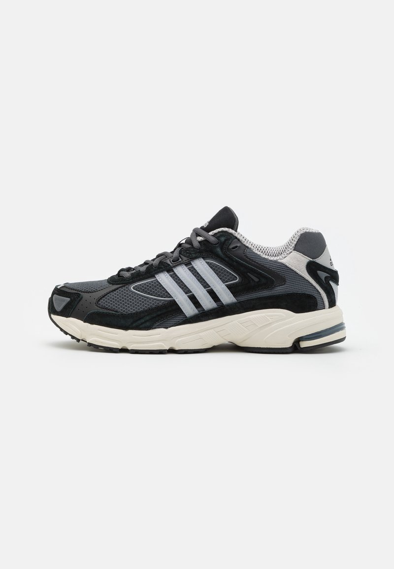 Baskets de sport noires et grises avec semelle blanche, tige en mesh et trois bandes argentées sur le côté, vues de l'extérieur.