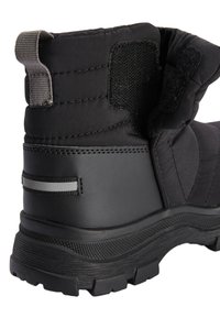 Botte isolante noire avec dessus matelassé, semelle en caoutchouc texturée, talon renforcé et bande réfléchissante horizontale. Fermeture velcro visible.