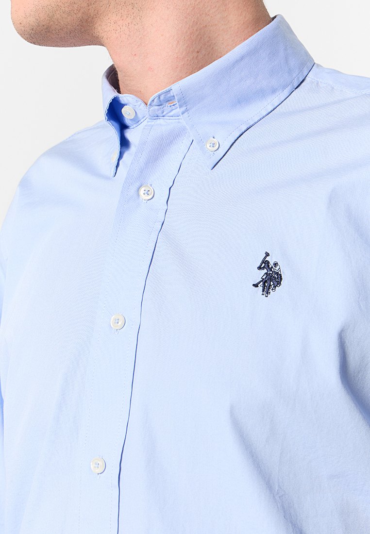 Helles blaues Hemd aus Baumwolle mit strukturiertem Finish. Verfügt über ein kleines gesticktes Logo auf der Brust und ein klassisches Kragendesign.