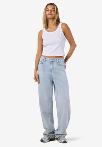 Balta dryžuota rankovių palaidinė derinama su šviesiai mėlynomis, plačiomis džinsų kelnėmis, pasižyminčiomis klasikinio penkių kišenių dizainu ir šviesiu skalbimo atspalviu.