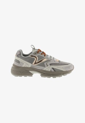 Zapatilla deportiva en beige y gris con paneles de malla, detalles metálicos y cordones marrones, mostrada desde el lado derecho.