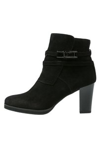 Bottine en suède noir avec un accent de boucle sur le côté, talon haut et bout arrondi. Possède une texture lisse et un design ajusté.