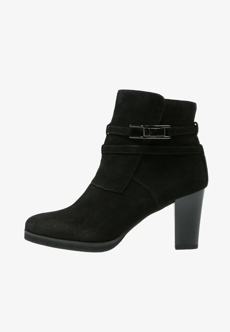 Bottine en suède noir avec un accent de boucle sur le côté, talon haut et bout arrondi. Possède une texture lisse et un design ajusté.