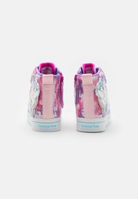 Un par de zapatillas altas coloridas para niños con diseño de unicornio, tonos rosa y púrpura, correas brillantes y el texto "Twinkle Toes" en las suelas.