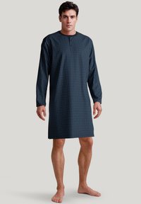Camicia da notte lunga a maniche lunghe di colore blu scuro con piccoli motivi geometrici bianchi, scollo rotondo e taglio dritto, realizzata in tessuto leggero.