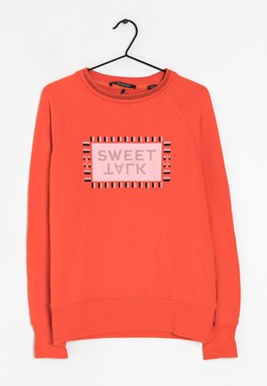 Sweatshirt orange à manches longues et col rond. Présente un graphique central avec "SWEET" en rose clair et des accents rayés noirs.