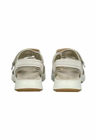 Sandal de color beige claro con correas ajustables, parte posterior abierta, parte superior de textil texturizado, plantilla acolchada y suela de goma blanca con acentos en color marrón.