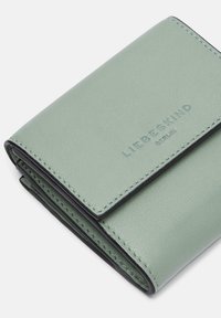 Zielona portfel skórzany z wypukłą fakturą i czarnym akcentem, z zapięciem na zatrzask i tłoczonym logo z przodu.
