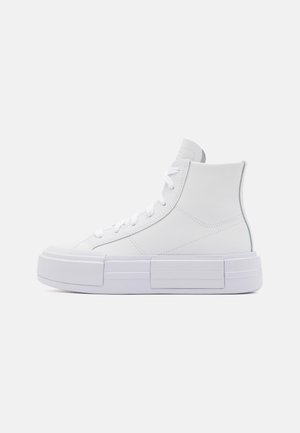 Białe sneakersy za kostkę z grubą podeszwą na platformie i sznurowadłami, pokazane z boku na gładkim jasnym tle.