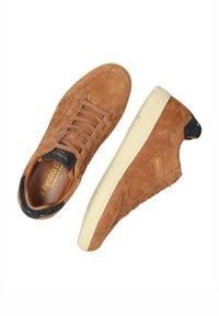 Braune Wildledersneaker mit strukturierten Akzenten, cremefarbenen Gummisohlen und Schnürdesign. Mit einem schwarzen Ferseneinsatz und einem goldenen Stern.