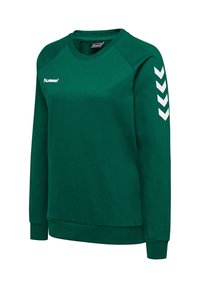 Sweat-shirt de sport vert à manches longues avec logo hummel blanc sur la poitrine et chevrons blancs sur la manche gauche, poignets et ourlet côtelés.