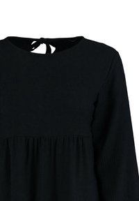 Abito lungo nero con maniche lunghe, scollatura rotonda e dettaglio con fiocco sul retro. Il tessuto texture e la vita arricciata creano una silhouette fluida.
