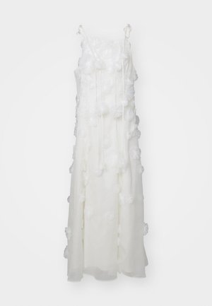 Robe blanche avec un tissu superposé, ornée de détails floraux en 3D, de fines bretelles et d'une silhouette fluide. La texture transparente ajoute de la profondeur au design.
