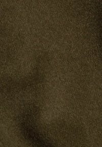 Ciemna oliwkowa zieleń miękkiego materiału o gęstej, puszystej fakturze, z widocznymi lekkimi fałdami i różnicami w powierzchni.